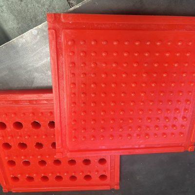 These are two different types of anti-slip mats: one is a red mat with studs and no holes, and the other is a red mat with studs and holes.
